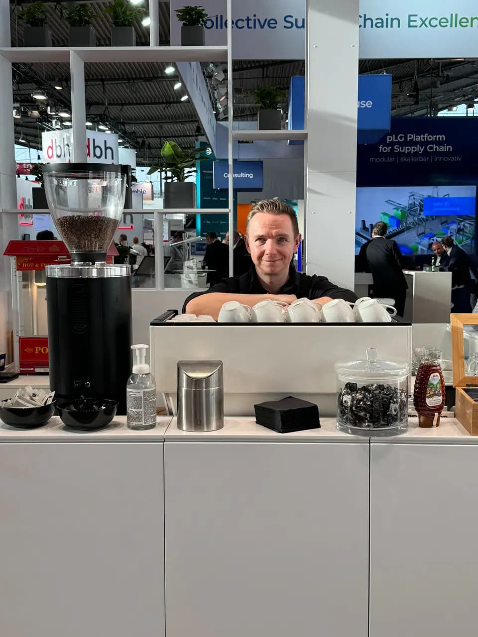 Kai Mößner hinter der Bar am Messestand, davor die Kaffeemühle